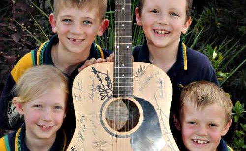 Chatsworth State School students (back from left) Zac Russell, Reuben Selby, (front) Shaqira Sewell and Lachlan Groves with the signed guitar which will be raffled to help air-condition the school. Chatsworth State School students (back from left) Zac Russell, Reuben Selby, (front) Shaqira Sewell and Lachlan Groves with the signed guitar which will be raffled to help air-condition the school.